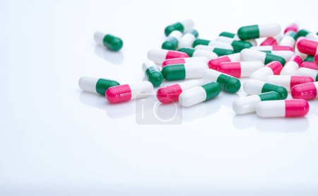 Photo for Capsules pill spread on white background. Prescription drugs. Capsule pill production. Green, pink, and white color capsule pills. Pharmaceutical industry. Medication and pharmacology. Health care. - Royalty Free Image