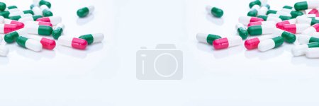 Photo for Capsules pill spread on white background. Prescription drugs. Capsule pill frame banner. Green, pink, and white color capsule pills. Pharmaceutical industry. Medication and pharmacology. Health care. - Royalty Free Image