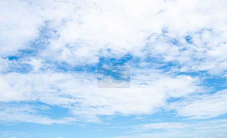 Piękne błękitne niebo i białe chmury abstrakcyjne tło. Chmurne tło. Błękitne niebo i puszyste białe chmury w słoneczny dzień z ptakami latającymi. Pogoda natury. Piękne błękitne niebo w letni dzień.