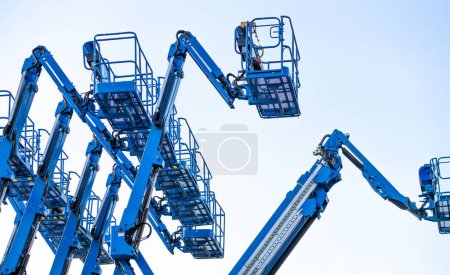 Articulated boom lift. Aerial platform lift. Telescopic boom lift against clear sky. Mobile construction crane for rent and sale. Maintenance and repair hydraulic boom lift service. Crane dealership.