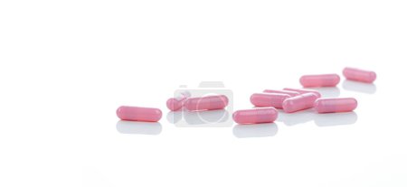 Cápsulas rosa píldora se extendió sobre fondo blanco. Medicamento recetado. Industria farmacéutica. Vitamina y cápsula de suplemento. Banner de farmacia. Industria farmacéutica. Asistencia sanitaria y atención médica.