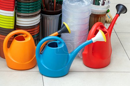 Photo for Plastic colorful watering cans gardening tools sold on market - Royalty Free Image