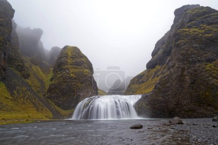 Téléchargez les photos : La belle cascade de Stjornafoss par un jour de pluie humide. - en image libre de droit