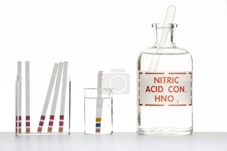 Foto de A sample of nitric acid being assessed with a pH color-fixed indicator stick. - Imagen libre de derechos