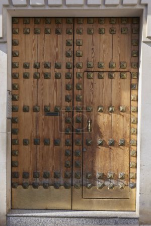 large, heavy, decorative nailed, wooden resident door