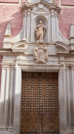 große hölzerne, schwer genagelte Tür mit Steinrahmen und Skulpturen. Toledo, Spanien. Spanien-Tour. Oktober 2023