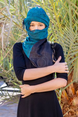 Foto de A beautiful model wears a hijab in the middle of the Sahara desert - Imagen libre de derechos