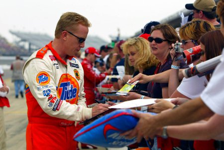 Foto de Ricky Craven takes time out to sign autographs for his fans during a practice session for the Sirius 400 NASCAR Winston Cup race at the Michigan International Speedway in Brooklyn, MI. - Imagen libre de derechos