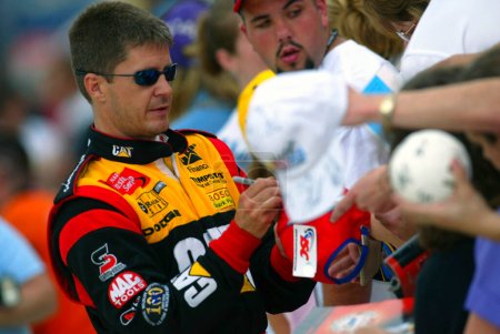 Photo for Ward Burton takes a moment to sign autographs for his fans during a practice session for the Sirius 400 NASCAR Winston Cup race at the Michigan International Speedway in Brooklyn, MI. - Royalty Free Image