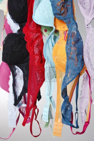 Foto de Un grupo de sujetadores de colores cuelgan en una línea de ropa en un ambiente de estudio - Imagen libre de derechos
