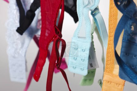 Photo for A group of colorful bras hang on a clothes line in a studio environment - Royalty Free Image