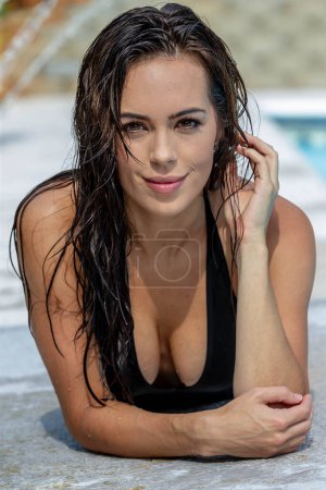 Photo for Stunning brunette bikini model luxuriates in a private pool, embodying elegance and relaxation in the comfort of her home oasis. - Royalty Free Image