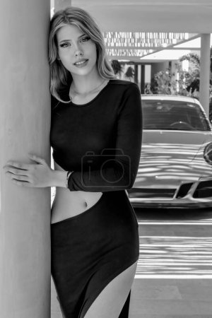 Exquisite model strikes a pose by a luxury European sports car, adding glamour to her Caribbean getaway, embodying elegance and opulence in paradise.