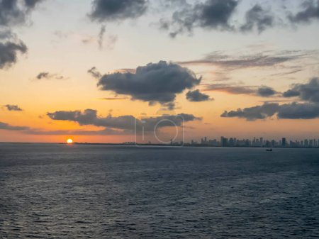 Während die Sonne über der Küste Miamis untergeht, legt ein Kreuzfahrtschiff anmutig ab und begibt sich auf ein karibisches Abenteuer, das ein goldenes Licht auf die ruhige See wirft