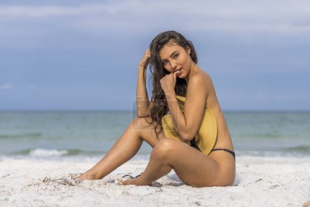 Un hermoso modelo de bikini de raza mixta disfruta del clima al aire libre en la playa