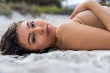 A beautiful mixed race bikini model enjoys the weather outdoors on the beach
