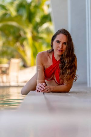 Junge Schönheit sonnt sich in der karibischen Sonne am Pool und genießt eine Urlaubsoase der Wärme, Entspannung und puren Glückseligkeit