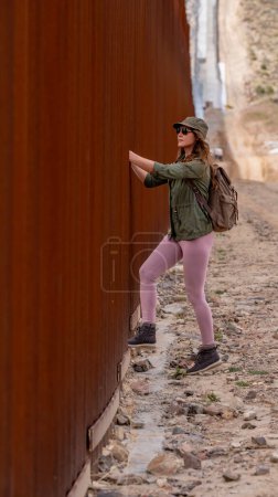 Photo for Desperate migrant navigates the Jacumba border wall, seeking illegal entry into the United States, highlighting ongoing immigration challenges - Royalty Free Image