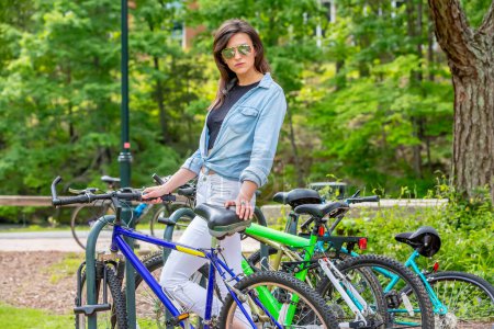 Foto de Una estudiante universitaria morena impresionante llega con gracia en su bicicleta, exudando elegancia y preparación para las clases del día - Imagen libre de derechos