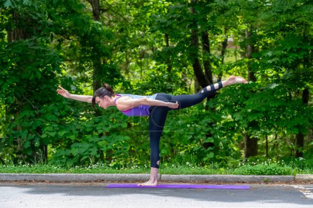 En medio del bullicio del campus, una estudiante universitaria morena serena encuentra tranquilidad a través del yoga, haciendo una pausa con gracia de las clases para un descanso rejuvenecedor