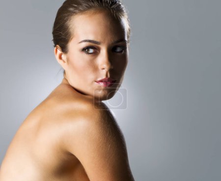 Stunning brunette model flaunts curves in studio shoot, exuding elegance and charm.
