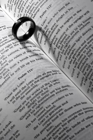 Unión simbólica: Banda de bodas descansa en el Libro de Mormón, proyectando una sombra en forma de corazón, encarnando el amor, el honor y el compromiso.