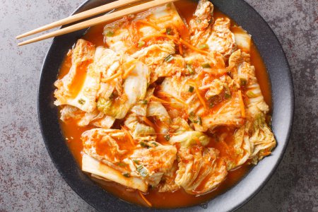 Cierre la comida coreana, la col Kimchi en un plato negro sobre una mesa. Vista superior horizontal desde arriba