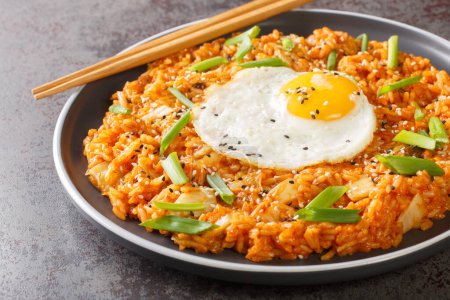 Photo for Homemade kimchi fried rice topped with fried egg closeup on the plate on the table. Horizonta - Royalty Free Image