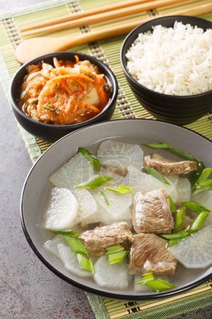 Foto de Soegogi muguk La sopa de res y rábano es una sopa muy popular en Corea que se sirve con arroz y kimchi en primer plano sobre la alfombra de la mesa. Vertica - Imagen libre de derechos