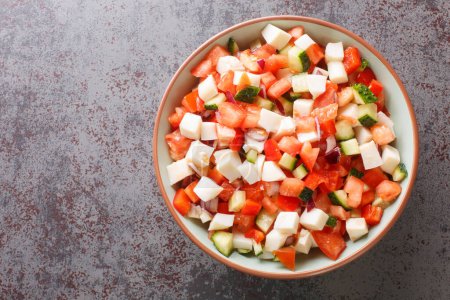 conch ceviche salad with vegetables such as tomatoes, cucumbers, onions, peppers close-up in a bowl on the table. horizontal top view from abov
