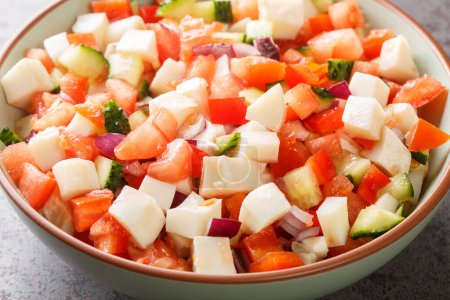 Foto de Conch ceviche salad with vegetables such as tomatoes, cucumbers, onions, peppers close-up in a bowl on the table. horizonta - Imagen libre de derechos
