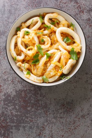 Téléchargez les photos : Squid with caramelized onions Calamares encebollados closeup on the plate on the table. Vertical top view from abov - en image libre de droit
