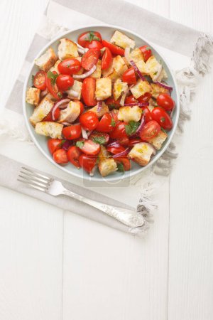 Photo for Acquasala Italian Puglian bread salad with cherry tomato closeup on the plate on the table. Vertical top view from abov - Royalty Free Image
