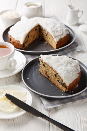 Photo for Boston bun, also known as a Sally Lunn, is a large spiced bun with a thick layer of coconut icing closeup on the table. Vertica - Royalty Free Image
