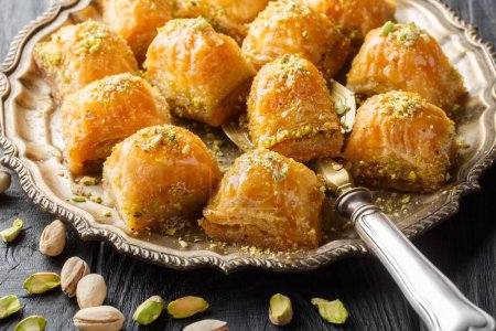 Photo for Traditional Turkish dessert pistachio baklava with honey close-up in a plate on the table. Horizonta - Royalty Free Image