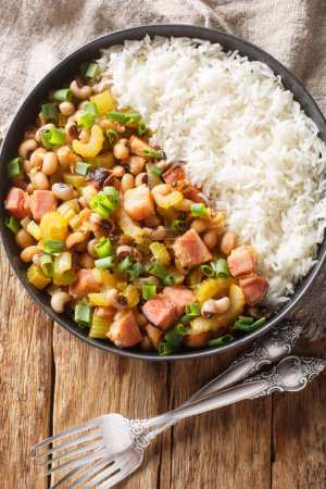 Photo for Hoppin john black eyed peas, sometimes called Carolina Peas and Rice, cooked with bacon, sausage, and veggies, and served over fluffy rice closeup. Vertical top view from abov - Royalty Free Image