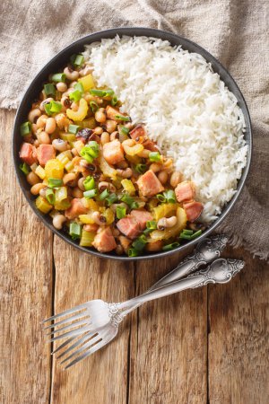 Photo for Hoppin John is one of those classic Southern dishes made of black-eyed peas and rice closeup on the plate on the wooden table. Vertical top view from abov - Royalty Free Image