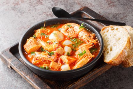Photo for Mediterranean soup of seafood and white fish with shrimp, mussels, scallops, squid close-up in a bowl on the table. horizonta - Royalty Free Image