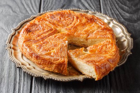 Photo for Kouign Amann is a pastry made with a lot of butter from the Brittany region of France closeup on the plate on the table. Horizonta - Royalty Free Image