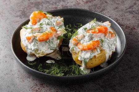Foto de Patatas escandinavas rellenadas con salsa de crema agria, ajo, eneldo y camarones de cerca en un plato sobre la mesa. Horizonta - Imagen libre de derechos