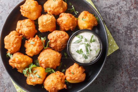 Photo for Hush puppies Deep fried cornmeal balls made with onions, garlic and butter closeup on the plate on the table. Horizontal top view from abov - Royalty Free Image