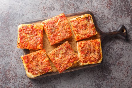 Photo for Sicilian sfincione italian pizza focaccia bread preppared with onions, tomato sauce, anchovies, caciocavallo cheese and bread crumbs closeup on the wooden board. Horizontal top view from abov - Royalty Free Image