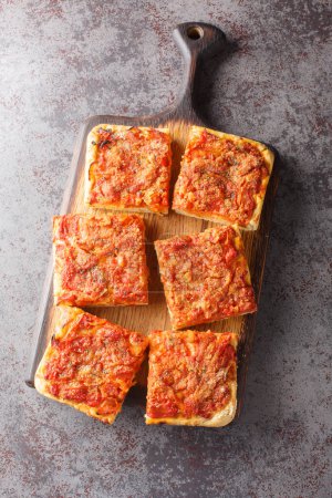 Photo for Traditional sfincione or Sicilian-style pizza with a homemade yeast crust and tomato onion sauce, cheese, and anchovies on top closeup on the wooden board on the table. Vertical top view from abov - Royalty Free Image