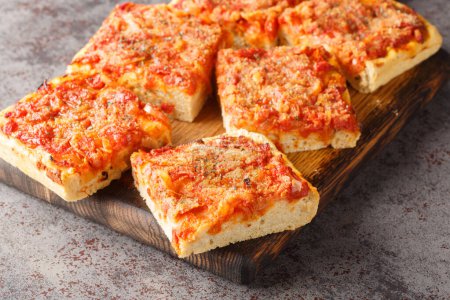 Foto de Pizza fincione con cebollas, tomates, queso, anchoas y pan rallado de cerca en el tablero de madera sobre la mesa. Horizonta - Imagen libre de derechos