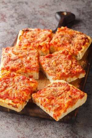 Foto de Sfincione Siciliano es una pizza de estilo siciliano coronada con migas de pan crujiente, queso rallado y primer plano de orégano en el tablero de madera sobre la mesa. Vertica - Imagen libre de derechos