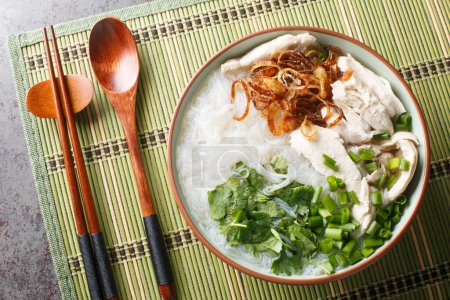 Photo for Delicious chicken soup with glass noodles mien ga is a Vietnamese dish that is guaranteed to comfort closeup on the bowl on the table. Horizontal top view from abov - Royalty Free Image
