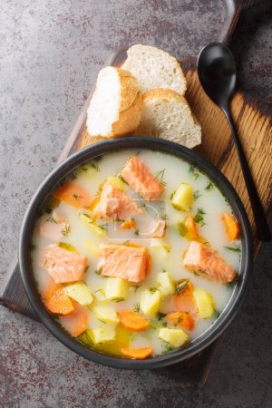 Téléchargez les photos : Soupe de poisson rouge crémeuse maison aux légumes et à l'aneth sur une assiette servie avec du pain en gros plan sur la table. Vue verticale du dessus depuis le dessus - en image libre de droit
