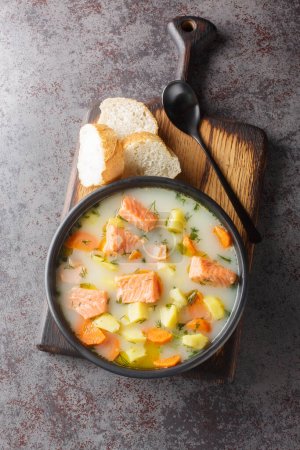 Téléchargez les photos : Soupe de poisson rouge crémeuse aux légumes sur une assiette servie avec du pain en gros plan sur la table. Vue verticale du dessus depuis le dessus - en image libre de droit