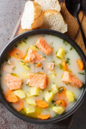 Téléchargez les photos : Soupe de saumon sauvage finlandaise avec crème et légumes-racines en gros plan sur une assiette sur la table. Vue verticale du dessus depuis le dessus - en image libre de droit