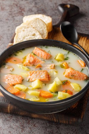 Téléchargez les photos : Soupe de saumon sauvage finlandaise avec crème et légumes-racines en gros plan sur une assiette sur la table. Vertica - en image libre de droit